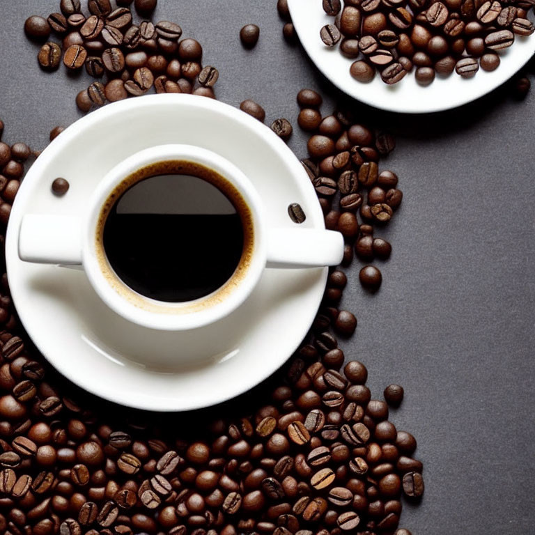 Coffee Cup with Saucer on Grey Surface and Scattered Beans