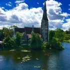 Gothic-style building by lake under blue sky with boats