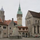 Medieval fantasy town with clock tower and figure in red