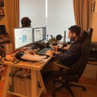 Person working on computer at cozy desk with snow-covered tree view