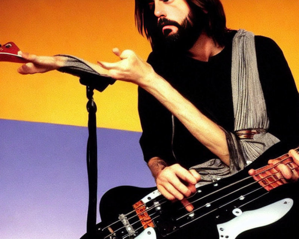 Bearded Musician with Electric Bass Guitar on Colorful Background