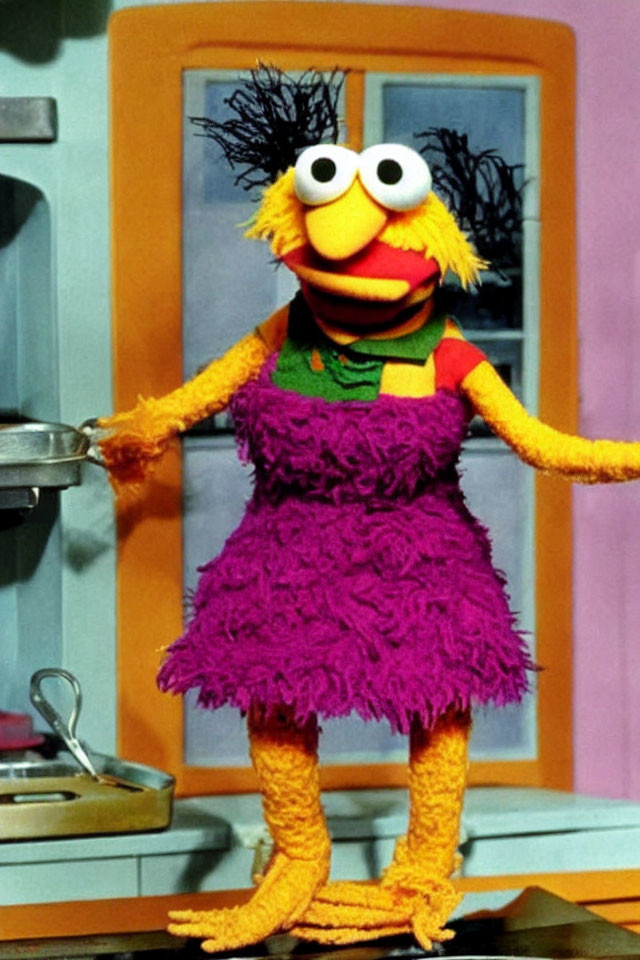 Colorful Puppet in Purple Dress with Frying Pan in Kitchen