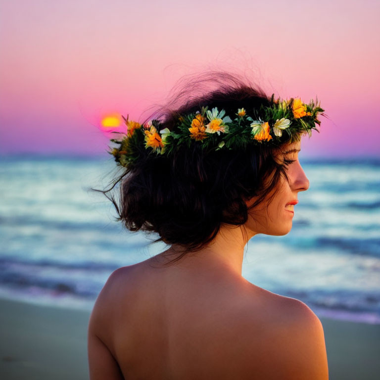 Person with floral crown gazing at ocean sunset with pink and blue sky