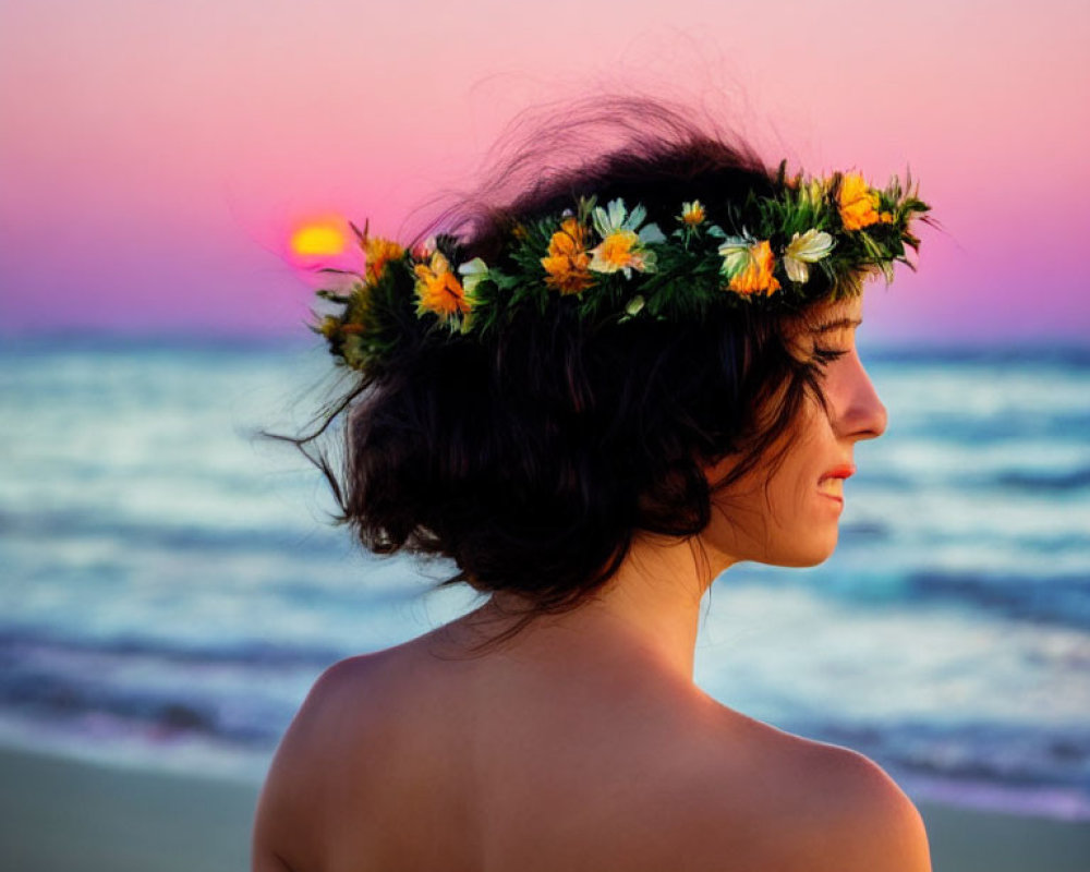 Person with floral crown gazing at ocean sunset with pink and blue sky