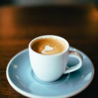 Digital painting of steaming coffee cup on saucer with spoon, warm abstract background