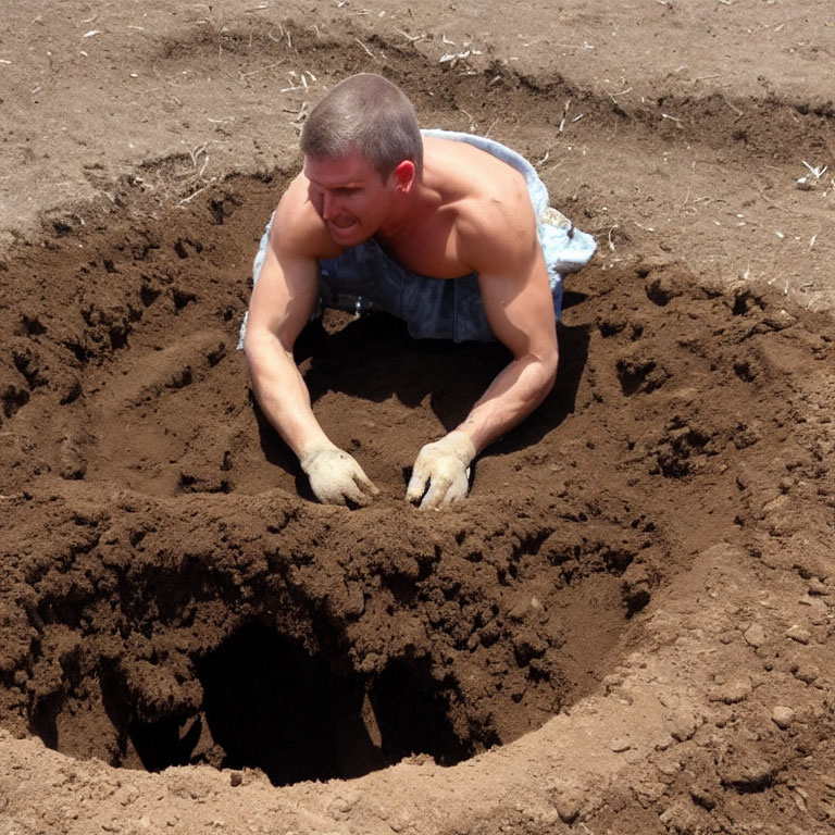 Man digging deep round hole in ground with gloves and sleeveless shirt