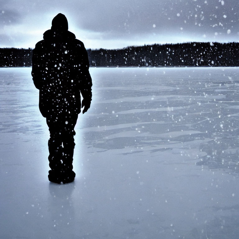 Figure standing on frozen lake in snowy landscape