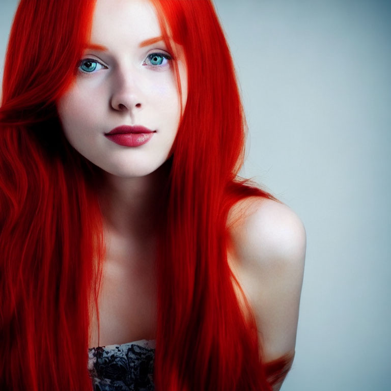 Red-haired woman with blue eyes and porcelain skin in subtle makeup gazes at camera