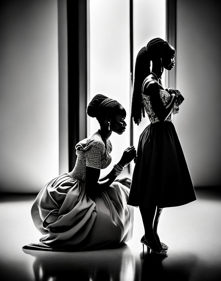 Silhouetted female figures with braided hair in elegant attire against softly lit backdrop