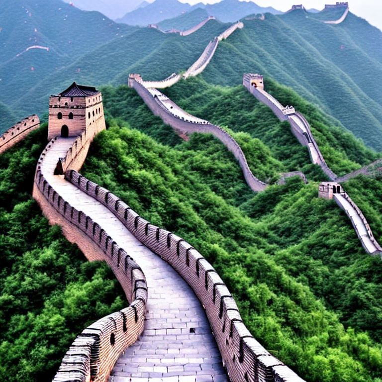 Iconic Great Wall of China in lush green hills under hazy sky