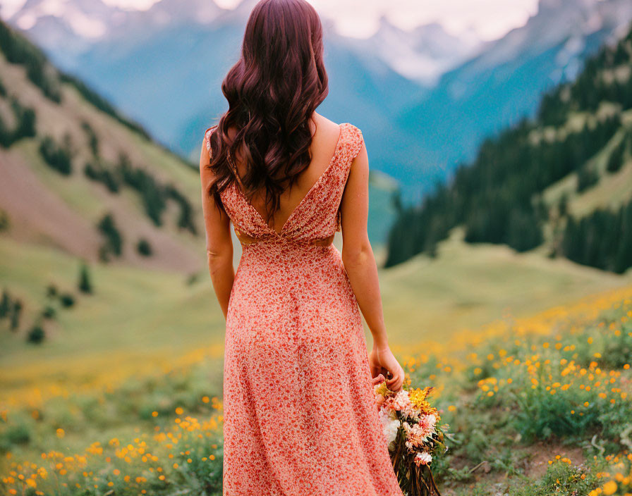 Woman in pink open back dress holding bouquet with mountain backdrop