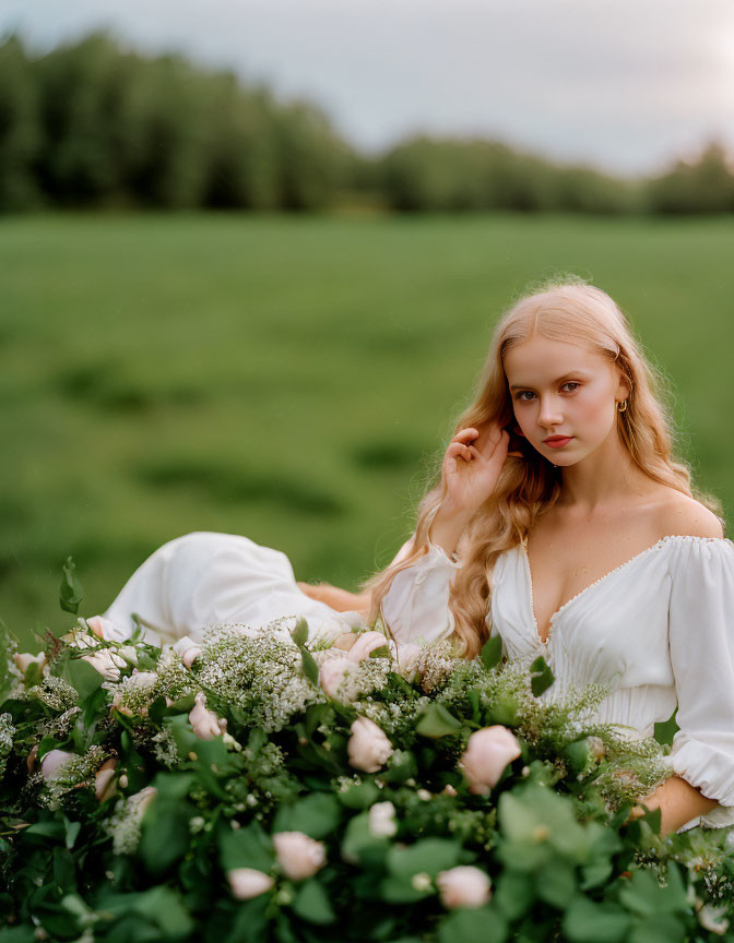 Woman in White Dress Poses with Flowers in Green Field