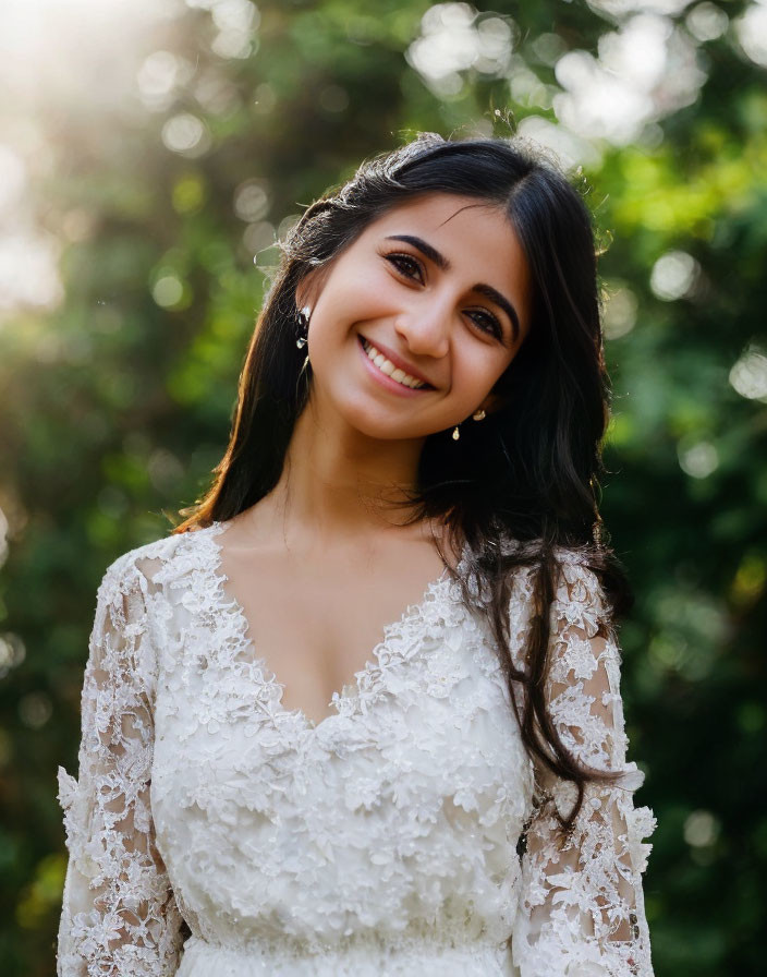 Smiling woman in lace bridal gown with natural makeup outdoors