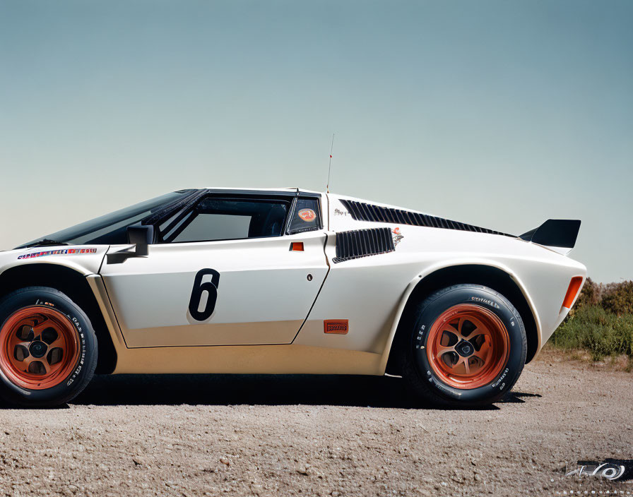 Vintage White Sports Car with Number 6, Black Details, and Orange Wheels on Road