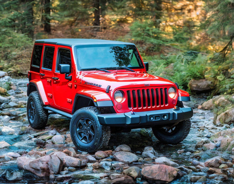 Red Four-Door Jeep Wrangler on Rocky Forest Trail with Stream