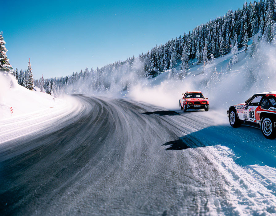 Rally cars racing on snowy mountain road with snow-capped trees