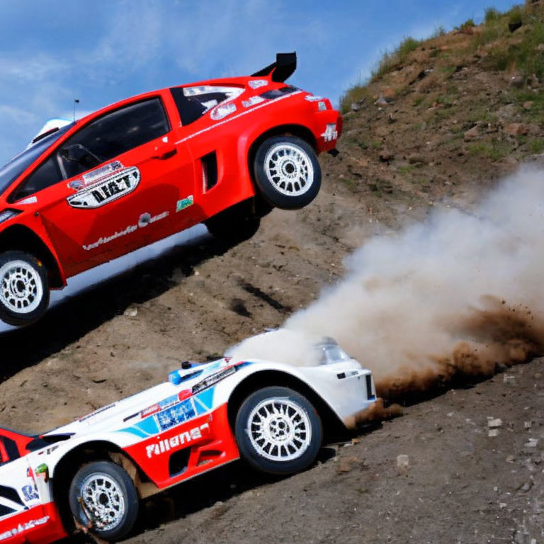 Red rally cars racing on dirt track, kicking up dust in sharp turn