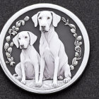 Circular bas-relief plaque featuring two sitting dogs and an olive branch on dark textured background