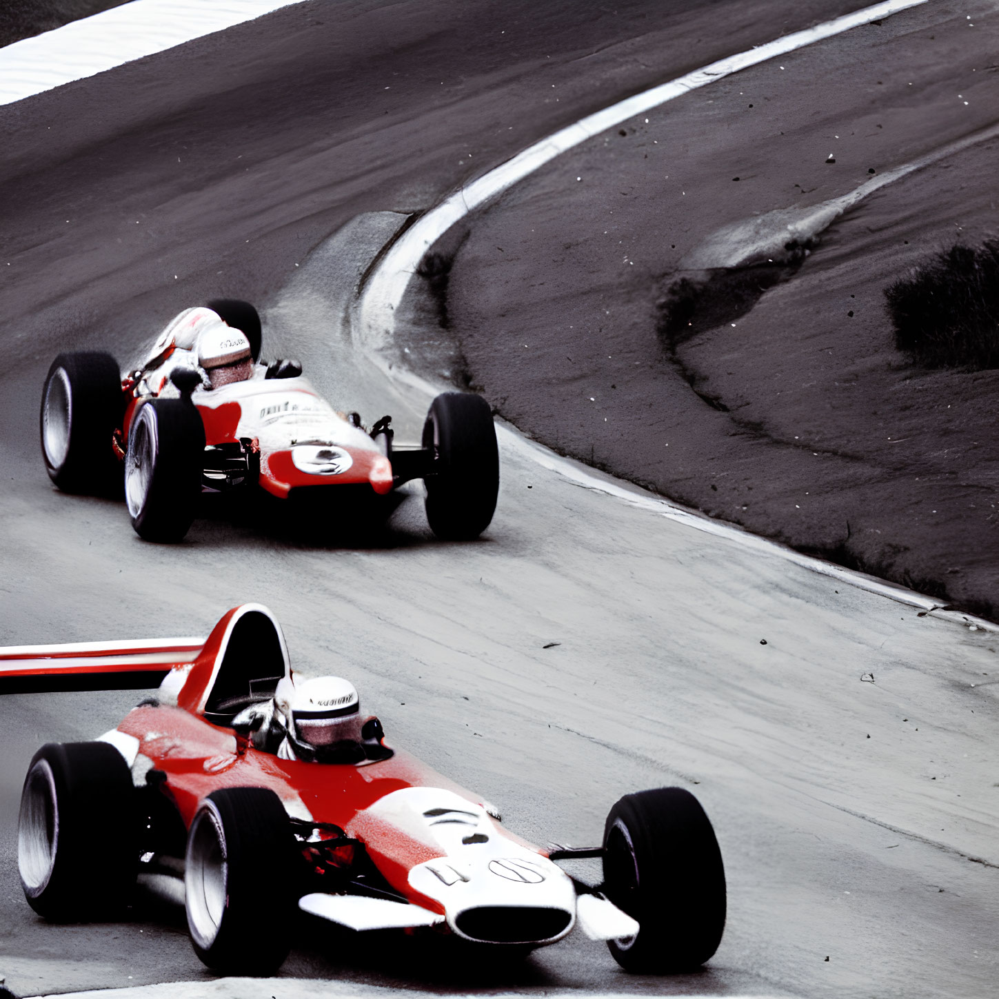 Vintage Formula 1 cars racing on curved track with selective color highlighting.