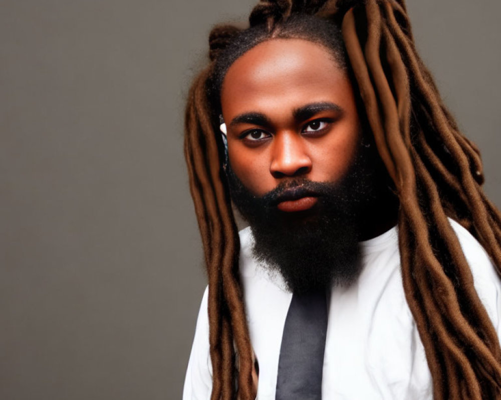 Bearded man with long dreadlocks in white shirt and tie