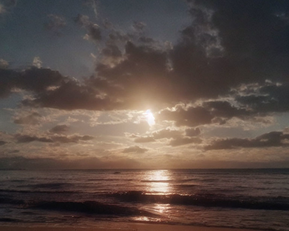 Scattered clouds over sunset ocean view from sandy beach