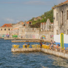 Picturesque European Village Along Serene River with Colorful Houses, Boats, and Whimsical