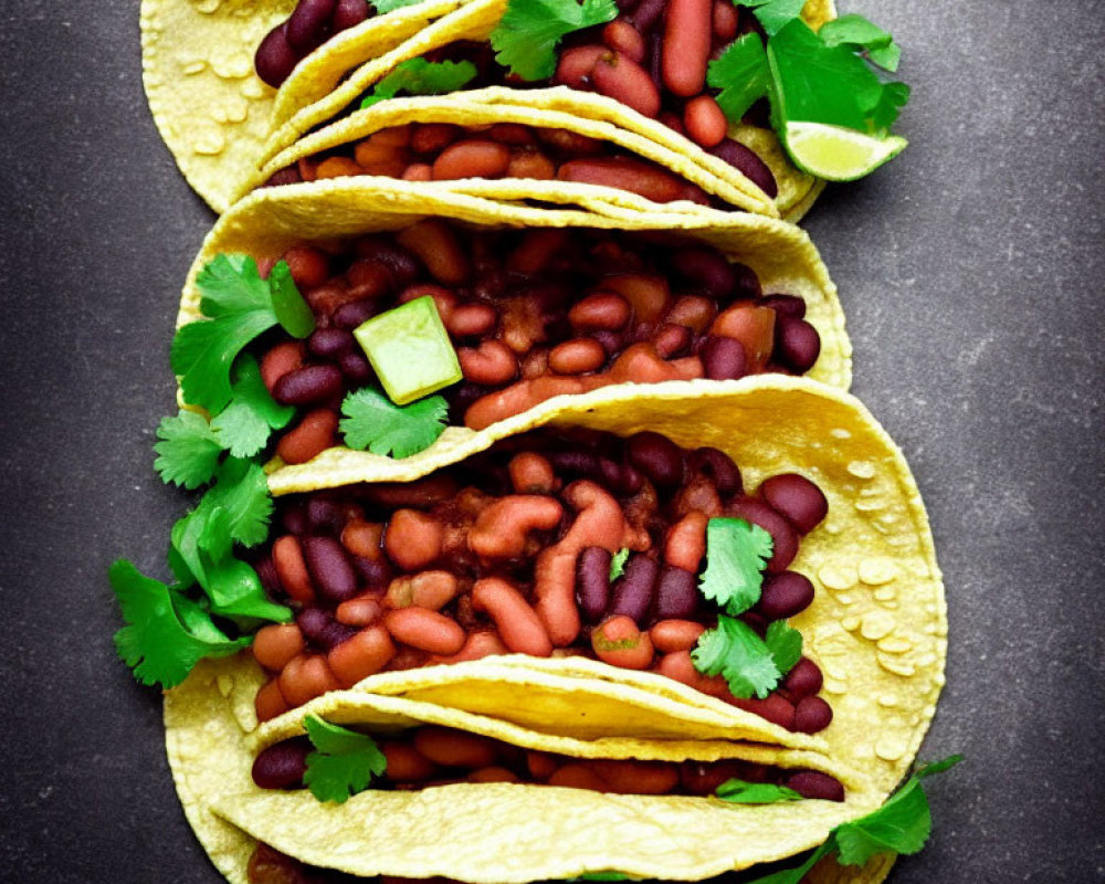 Mexican-style red bean-filled corn tortillas with cilantro and lime on dark background