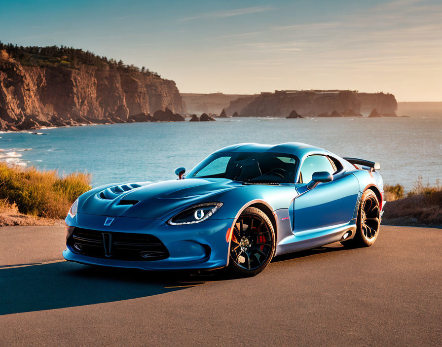 Blue sports car parked on coastal road at sunset with cliffs and ocean