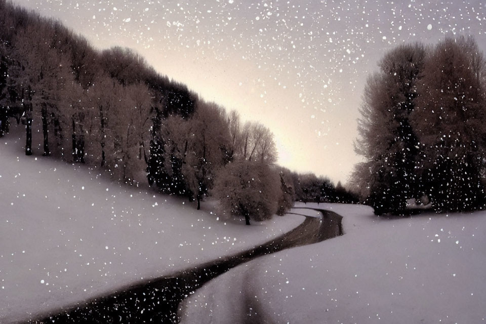 Snow-covered landscape with winding road and bare trees under twilight sky