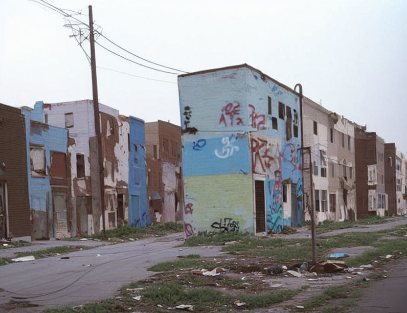 Abandoned buildings with graffiti under overcast sky