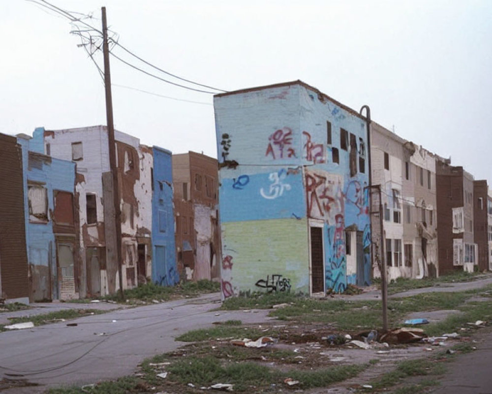 Abandoned buildings with graffiti under overcast sky