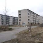 Abandoned urban street with graffiti-covered buildings and distant skyscrapers