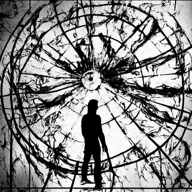 Silhouette of person in front of shattered circular window