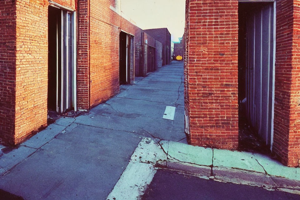 Red brick alley with clear sky and distant vehicles