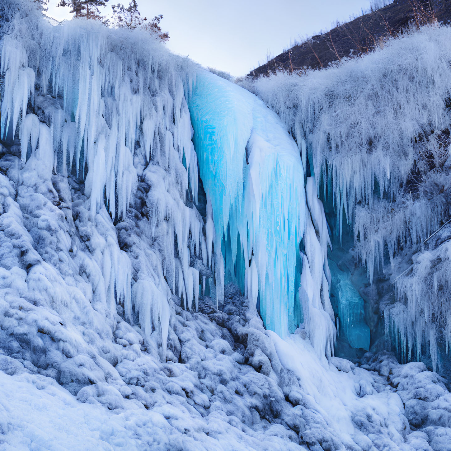 Frozen Waterfall with Blue and White Ice Formations Amid Frosty Vegetation