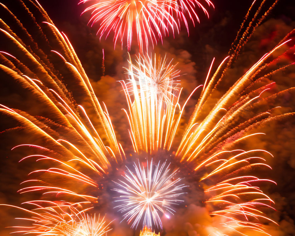 Colorful fireworks illuminate night sky above building silhouette