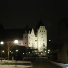 Castle at Night with Illuminated Spire and Trees