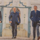 Progressively translucent images of a man in a blue suit walking against abstract background.