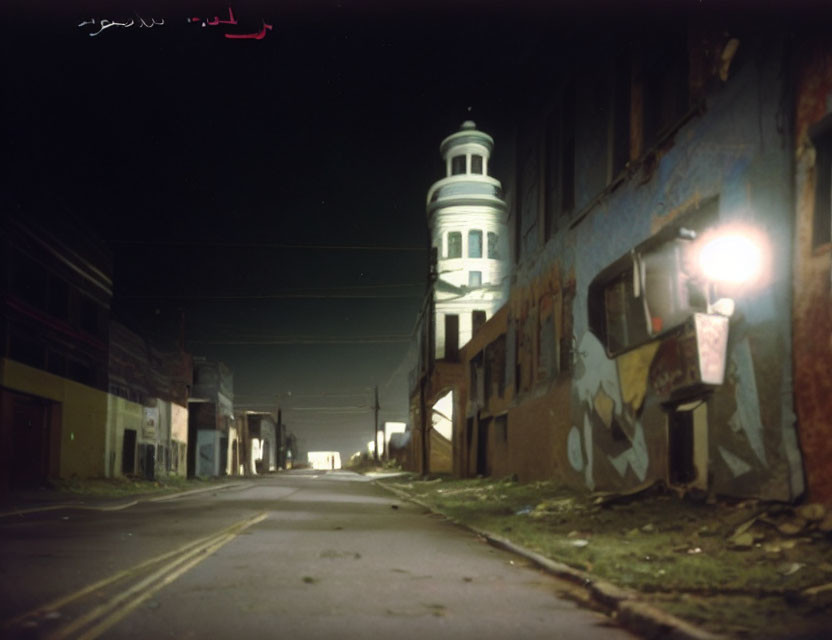 Deserted Street at Night with Graffiti and Lit Streetlamp