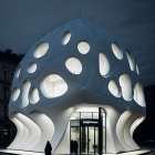 Futuristic dome-shaped building with circular windows in urban night scene