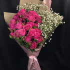 Human hand holding vibrant bouquet of flowers on dark background