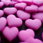 Pink Heart-Shaped Objects in Varying Shades on Dark Background