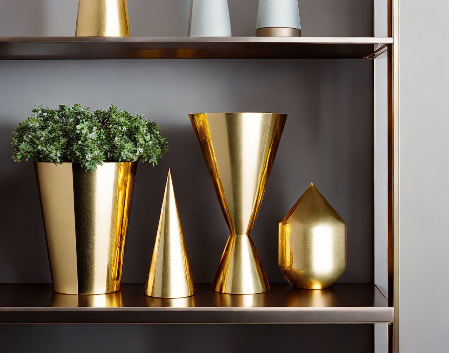 Geometric gold vases and green plant on modern shelf