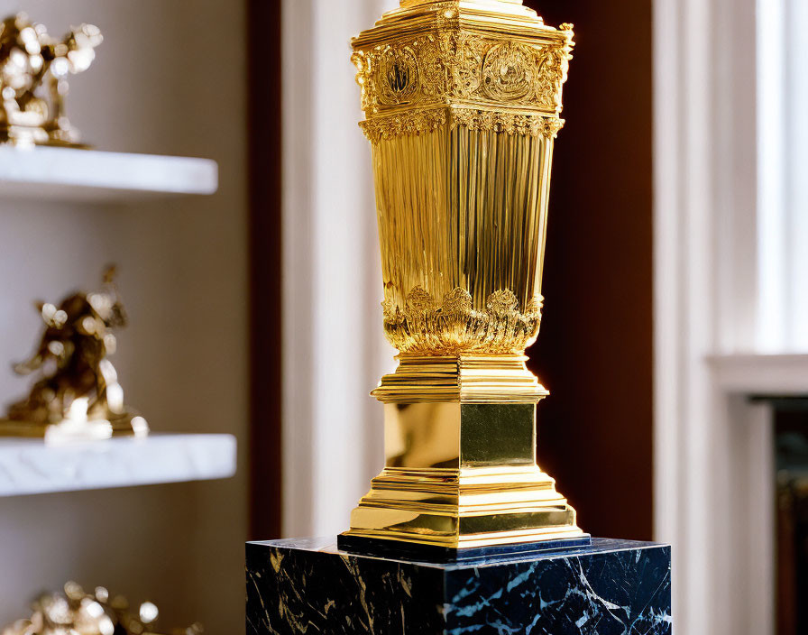 Golden trophy on marble pedestal in room with sculptures