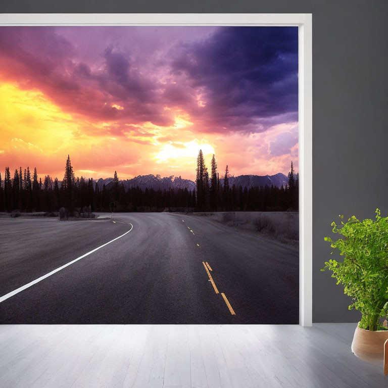 Scenic road mural with purple and orange sunset in room with plant