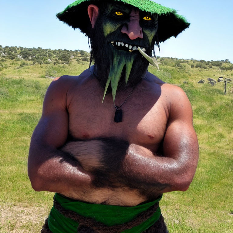 Muscular person with orc head in green hat on grassy field under blue sky