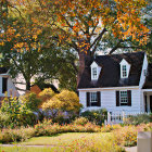 White Cottage Surrounded by Autumn Foliage and Winding Path