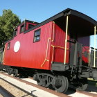 Ornate Red and Gold Steam Train at Station with Scenic Landscape