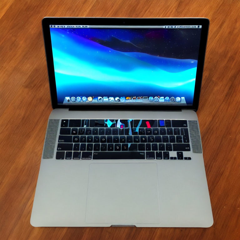 Laptop on Wooden Table with Cosmic Wallpaper and Trackpad