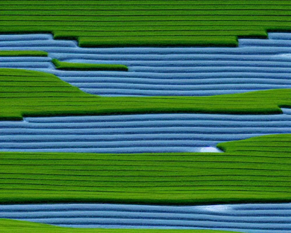 Vibrant green and blue terraced agricultural fields in a topographic pattern